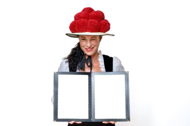 Black Forest waitress in a traditional Bollenhut with red pompoms who winks mischievously and holding open a blank menu with copy space with a friendly smile clipart