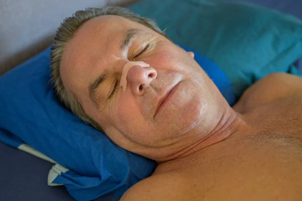 Крупным Планом Спящего Мужчины Средних Лет Носовой Лентой Лежащей Постели — стоковое фото