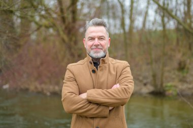 Gri saçlı ve gri sakallı orta yaşlı bir adamın portresi. 