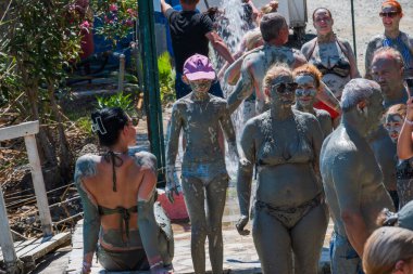 Dalyan 'da Doğa Spa Günü. Mutlu gezginler Dalyalıların ünlü çamur banyosunun iyileştirici gücüyle yıkanırlar. Gelenek, kahkaha ve sağlık. 