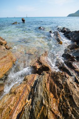 Berrak suyun canlı taşlarla buluştuğu kayalık bir kıyı şeridinin nefes kesici manzarası. Yumuşak dalgalar kıyıya vuruyor, sakin ve sakin bir atmosfer yaratıyor doğa severler için mükemmel..