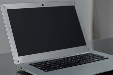 Boş ekranlı metalik bir dizüstü bilgisayar, minimalist bir tasarımı vurgulayan parlak bir yüzeye dayanır. Teknoloji teması ya da çalışma alanı kavramları için mükemmel.