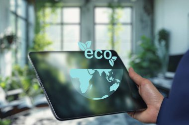 Bir kişi, içinde bir dünya ve yaprakların bulunduğu, çevre dostu bir konsept içeren bir tablet tutuyor. Bu görüntü sürdürülebilirliği, teknolojiyi ve çevresel farkındalığı temsil eder..