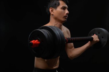 Odaklanmış bir adam halterin ağırlığını kaldırır ve spor yolculuğunda kendini adamıştır. Sağlık, eğitim ve vücut koşullandırmasını temsil etmek için mükemmel..