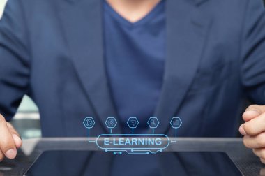 Modern bir işadamı bir tablet sergisi e-öğreniyor. Bu görüntü, teknolojinin yenilikçi dijital eğitim deneyimlerinin şekillendirilmesindeki rolünü yakalar..