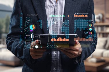 Modern bir iş adamı dijital tabletle etkileşime girer ve veri görselleştirme grafiklerini gösterir. Bu görüntü teknoloji ve iş dünyasının kesişimini yakalar, veri analizini ve daha iyi karar verme mekanizmasını sembolize eder..