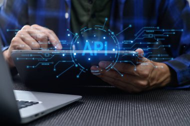 Bir geliştirici, dijital bağlantılar ve veri sembolleriyle çevrili yenilikçi bir API arayüzü gösteren, modern programlama çözümlerini vurgulayan bir tabletle bağlantı kurar.