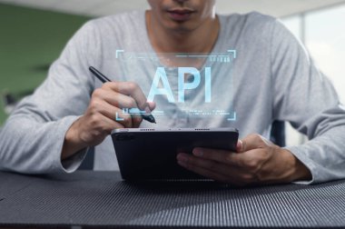 Odaklanmış bir programcı API geliştirme ve dijital teknolojiyi gösteren bir tablet üzerine yazar. Yazılım verimliliğini ve yeniliğini göstermek için ideal.