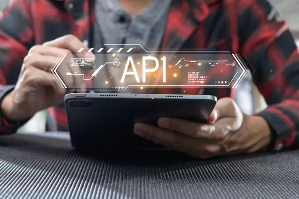 API arayüz grafiğini gösteren bir tabletle odaklanmış bireysel etkileşim. Bu resim dijital çalışma alanındaki modern teknoloji ve programlama kavramlarını vurgular.