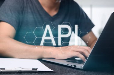Bir programcı, bir uygulama programlama arayüzü (API) geliştirmeye odaklanmış bir dizüstü bilgisayar üzerinde çalışır. Görüntü, dijital çalışma alanındaki modern kodlamanın özünü yakalıyor..