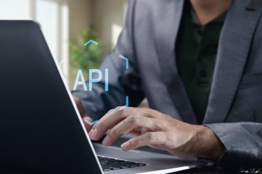 API konseptini gösteren bir dizüstü bilgisayara odaklanmış birey tipi. Bu resim, modern bir çalışma alanı ortamında programlama ve teknolojinin özünü yakalar..