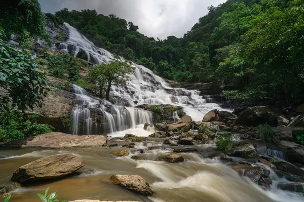 Chiang Mai, Tayland 'da canlı yeşillikler ve çarpıcı kaya oluşumlarıyla çevrili bir şelalenin nefes kesici güzelliğini keşfedin. Doğa aşıkları için mükemmel.!