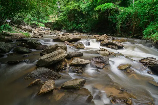 Chiang Mai, Tayland 'ın gür ormanlarında taşların üzerinden akan sakin bir şelalenin huzur veren güzelliğini tecrübe edin. Doğayı severler ve turistler için mükemmeldir..