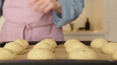 Pişirmeden önce üzümlü çörekleri yumurta ve sütle fırçalamak