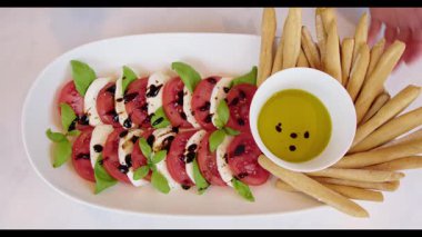 Caprese Salatası Grissini ve Zeytinyağı ile servis edilir.