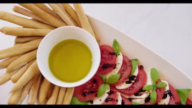 Caprese Salatası Grissini ve Zeytinyağı ile servis edilir.