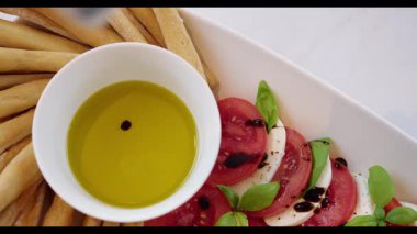 Caprese Salatası Grissini ve Zeytinyağı ile servis edilir.