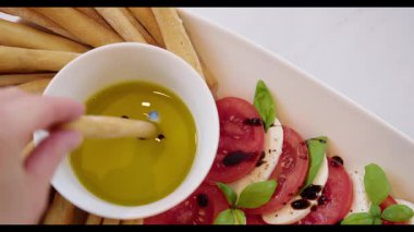 Caprese Salatası Grissini ve Zeytinyağı ile servis edilir.