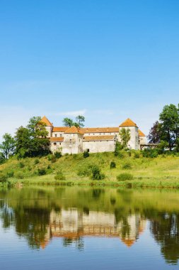 Svirzh Castle reflected in lake water. Lviv region, Ukraine