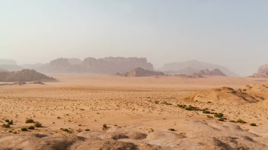 Wadi Rum Çölü manzarası, Ürdün, Ay Vadisi. Turuncu kum, sis. Gün doğumu duvar kağıdı. Dünya simgeleri. Toprağın güzelliğini keşfedin. Ulusal park açık hava manzarası.