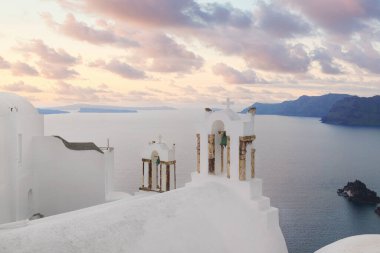 Santorini Adası, Yunanistan 'da beyaz mimari. Caldera deniz manzaralı ve bulutlu gündoğumu gökyüzü olan güzel bir manzara. Yaz tatilinde. Balayı ve mikro etkinlikler için en iyi yer..