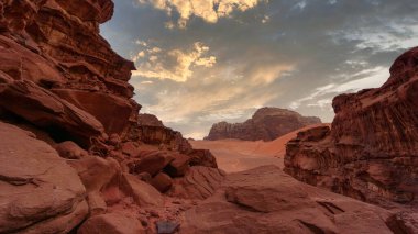 Wadi Rum Çölü 'nün görkemli manzarası, Ürdün, Ay Vadisi. Turuncu kum ve kayalar, fırtına bulutları. Gün batımı duvar kağıdı. Dünya simgeleri. Toprağın güzelliğini keşfet. Akşam, açık hava manzarası.