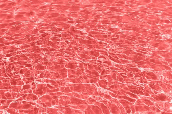 Close-up of a swimming pool filled with bright red water. The water is illuminated from below, creating an unnatural, dreamlike scene. Perfect for pool parties, night swims, or a pop-art aesthetic.