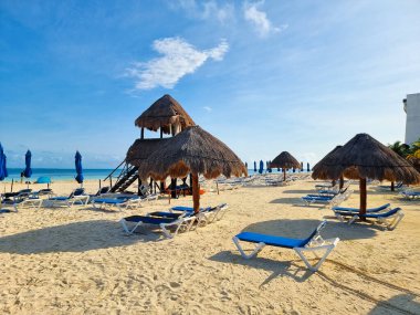 Meksika, Cancun, güneş doğarken sazdan şemsiyeli plaj ve cankurtaran kulesi.