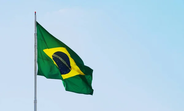 巴西国旗在美丽而晴朗的天空中飘扬 阳光照亮了国旗 左边的巴西国旗 右边有文字空间 — 图库照片