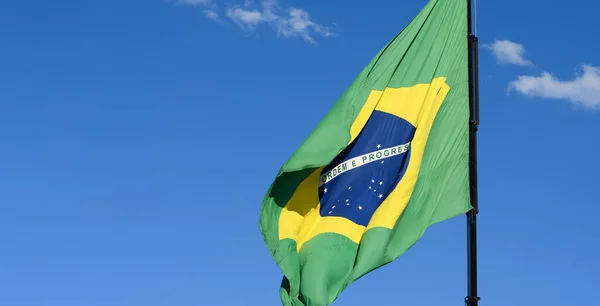 Бразильский Флаг Размахивающий Красивым Голубым Небом Солнечным Светом Освещающим Флаг — стоковое фото
