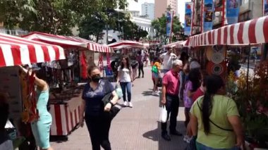 Sao Paulo, SP, Brazil - December 31, 2022: walking by the open air fair of Liberdade neighborhood. People selling handicrafts and plants at Liberdade square.