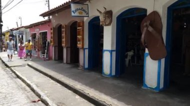 Arraial d'Ajuda, district of Porto Seguro, BA, Brazil - January 04, 2023: walking on the Historic Center of Arraial d'Ajuda, view to the shops and the Nossa Senhora d'Ajuda church.