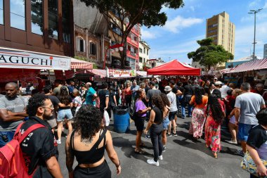 Sao Paulo, SP, Brezilya - 07 Nisan 2024: Liberdade açık hava fuarındaki insanlar yiyecek satan çadırlarda. 