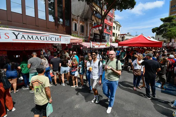 Sao Paulo, SP, Brezilya - 07 Nisan 2024: Liberdade açık hava fuarındaki insanlar yiyecek satan çadırlarda. 