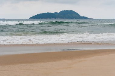 Guaruja 'nın Tombo plajı - SP, Brezilya' nın arka planında Farol da Moela adası var. Sahilin manzarasında hiç insan yok..