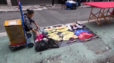 Sao Paulo, SP, Brezilya - 07 Nisan 2024: Liberdade caddesinde doğu ürünleri satmaya hazırlanan sokak satıcısı.