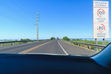 Driving the car on the Helio Serejo bridge, over the Parana river, on the BR-267 highway. Bridge that divides the states of Mato Grosso do Sul and Sao Paulo. clipart