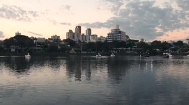 Ipago Gölü 'nün zaman atlaması Londrina şehri, Parana, Brezilya. Gün batımında gölün güzel manzarası ve suda pedallı tekneler..