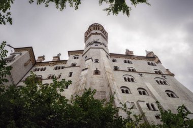 Fussen 'deki Neuschwanstein Şatosu, XIX yüzyılının şaşırtıcı neo gotik sarayı ve Almanya' nın en ünlü Bavyerası. Yağmurlu bulutlu bir günde aşağıdan görünüm
