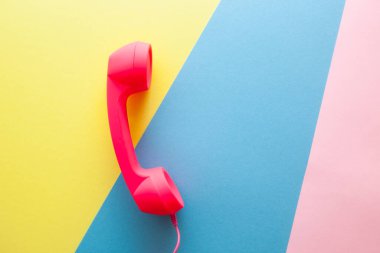 Phone or handset on yellow, blue and pink background, colorful card with communication and connection concept