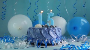 15. yaş günün kutlu olsun. Donanma pastası ve mavi balonlu on beşinci mum, yıldönümü kutlaması.