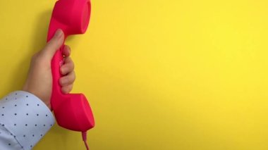 Sarı arka planda pembe telefonlu bir kadın arıyor, yavaş çekimde iletişim.