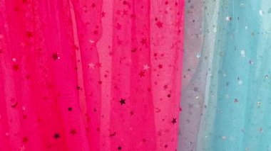 Kutlama arkaplanı pembe ve mavi, yeşil tekstil ve parıltılı yıldızlar ve noktalar yavaş çekimde dekorasyon