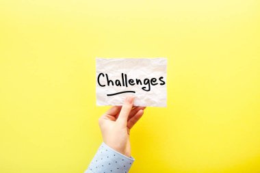 Challenges - card in hand with text about motivation on yellow background clipart