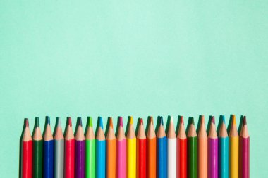 Açık yeşil zemin üzerinde farklı renk kalemleri satır kopyalama alanı, sanat ve eğitim tarzı kartı