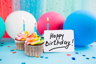 Doğum günün kutlu olsun. Mesajlı kart, mumlu kekler, mavi balonlar.