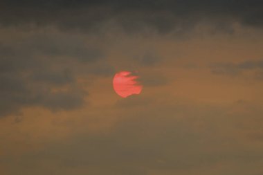 Güneşin dumanlı sisli bir yangındaki görüntüsü.