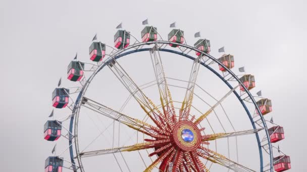 狂欢狂欢节 摩天轮 车轮旋转 多彩的摩天轮在阴天慢速旋转 大圆形金属结构用于观察 — 图库视频影像