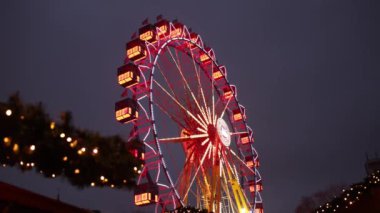 Dönme dolap, lunapark, metal yapı. Bir lunaparkta dönme dolap, parlak renkli dönme dolap, sürüşün detayları, metal inşaat, büyük dönme dolap ve gözlem taksileri.