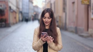 Kadın konuşuyor, cep telefonu konuşuyor, sokakta yürüyor. Yürüyen bir kadın, çekici bir sırt çantalı, şehirde yürürken sohbet eden güzel bir turist, akıllı telefon kullanarak sokaklarda tek başına gezen bir gezgin.